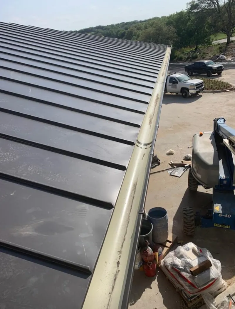 Standing seam panel and gutter detail on a metal roofing jobsite in Westwood